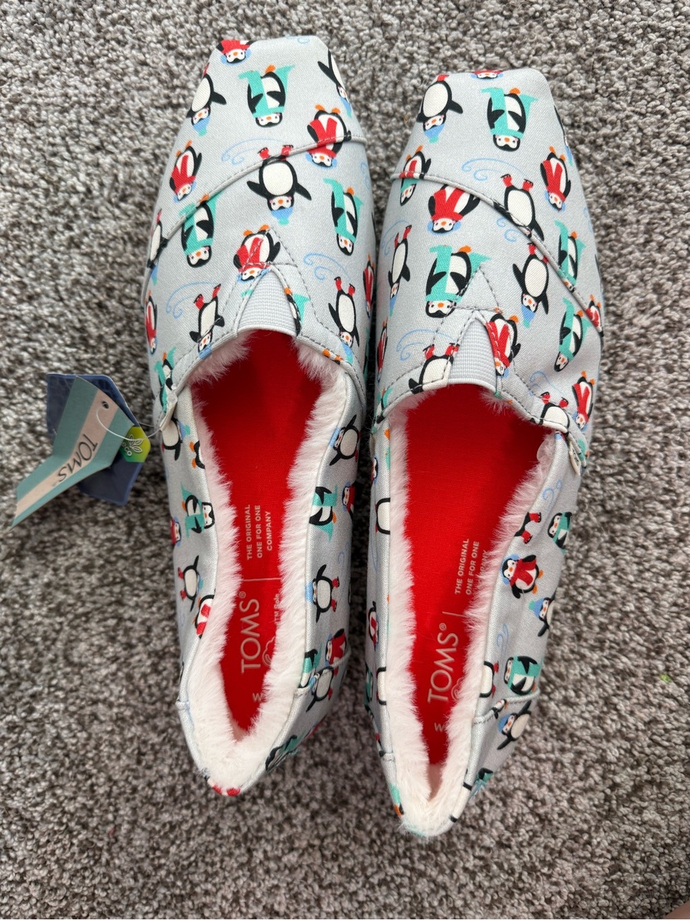 TOMS women’s Penguin Print Slip-On Shoes in Light Blue, Red, Black, Teal